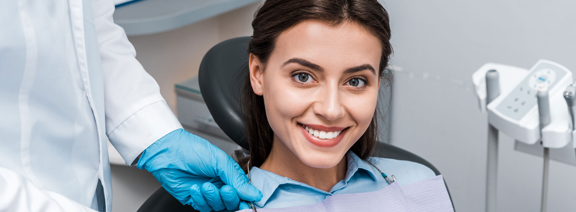 A woman sitting in a dental chair, receiving dental care.