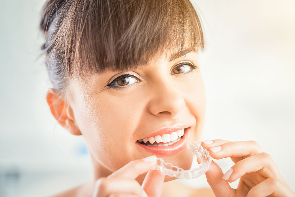 A woman brushing her teeth with a toothbrush.