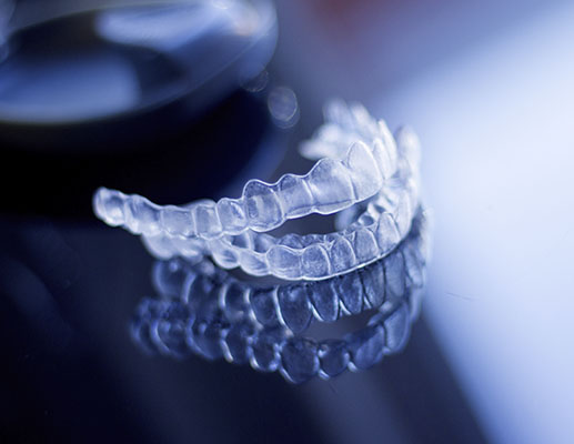 Innovative dental implant technology showcased with transparent braces and a clear plastic model.