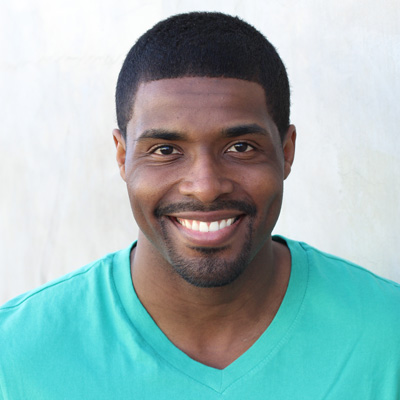 An elderly couple sitting close together, smiling and posing for a photo.
