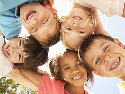 A group of six children, both boys and girls, smiling and posing together for a photo.